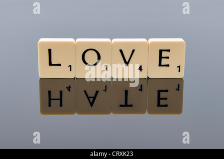 Scrabble lettere l'ortografia della parola amore con la parola odio come la sua riflessione, il concetto di una linea sottile tra amore e odio Foto Stock