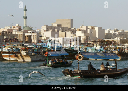 I taxi d'acqua sul Dubai Creek davanti lo skyline della città vecchia di Dubai Foto Stock