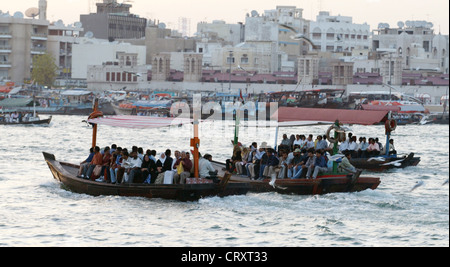 I taxi d'acqua sul Dubai Creek davanti lo skyline della città vecchia di Dubai Foto Stock