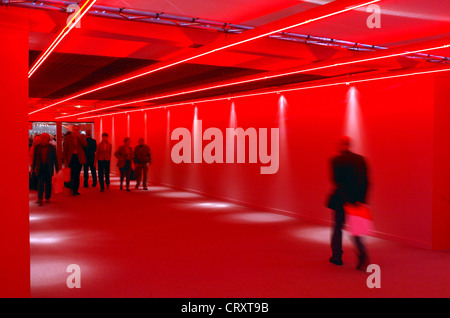 La gente passare attraverso un ingranaggio rosso, e.on AGM a Essen Foto Stock