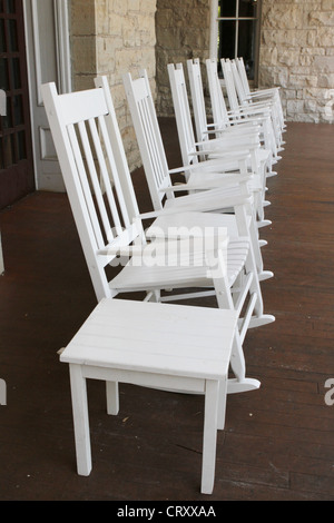 Una fila di bianco sedie a dondolo su un lungo porticato al Crescent Hotel a Eureka Springs, Arkansas. Foto Stock