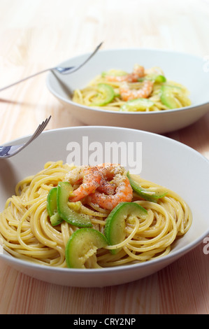 Spaghetti di pasta fresca con gamberi e zucchine salsa sopra il tavolo in legno Foto Stock