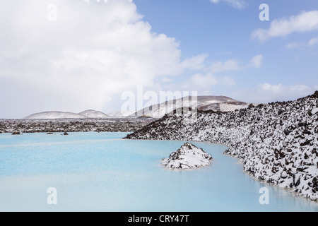 Vista panoramica sulla laguna blu, Islanda con montagne coperte di neve in background Foto Stock