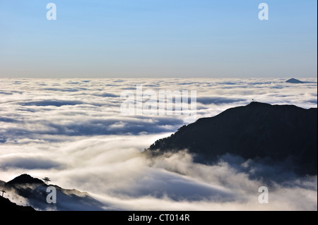 Vista su stagliano le seggiovie e le montagne coperte dalla nebbia di sunrise, Col du Tourmalet, Hautes-Pyrénées, Pirenei, Francia Foto Stock