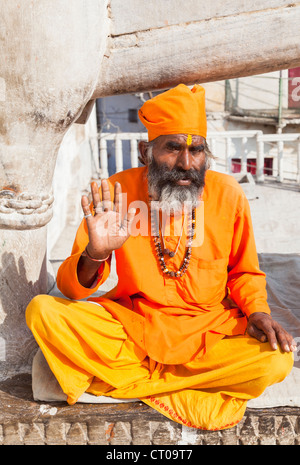 Sadhu, Indù indiano santo uomo, vestito in tradizionali abiti dello zafferano, dando una benedizione per la ALMS a Tempio Jagdish in Udaipur, Rajasthan, India Foto Stock