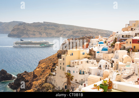 Vista di waterside clifftop di edifici e il Jade norvegese la nave di crociera, Oia - Santorini, Grecia Foto Stock