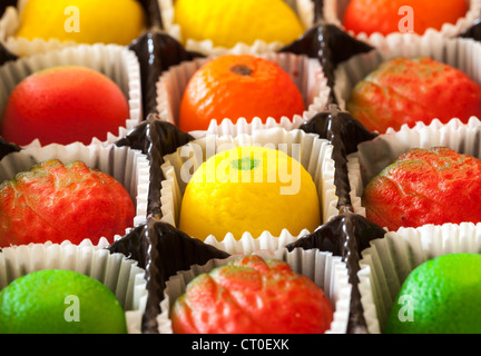 A forma di frutta caramelle in una macro immagine di marzapane dolci in involucri di carta Foto Stock