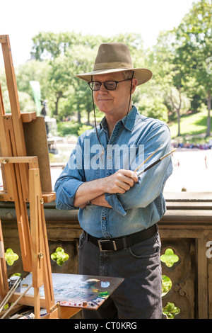 Un pittore che lavora su un cavalletto, al Central Park di New York Foto Stock