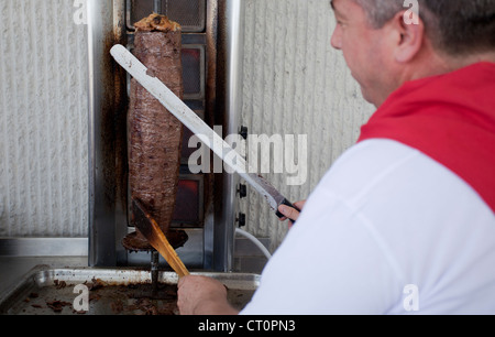 Lo chef Turco slicing Döner Kebab Foto Stock
