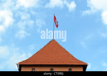 Trakai torre di castello e battenti bandiera sullo sfondo del cielo nuvoloso. XIV, XV secolo architettura. Foto Stock