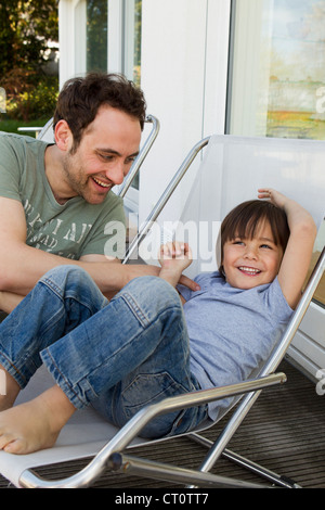 Padre e figlio giocando in sedie a sdraio Foto Stock