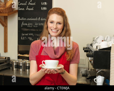 Server con caffè dietro il contatore da forno Foto Stock