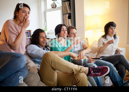 Gli amici a guardare un film in salotto Foto Stock