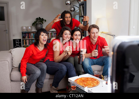 Gli amici a guardare lo sport in TV Foto Stock