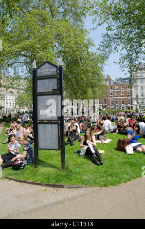 I londinesi di mangiare il pranzo in una giornata di sole in Cavendish Square Gardens Foto Stock