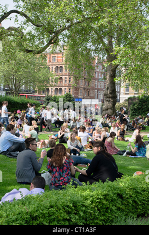 I londinesi di mangiare il pranzo in una giornata di sole in Cavendish Square Gardens Foto Stock