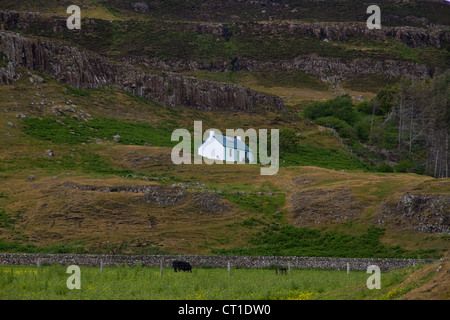 Un piccolo bianco tradizionale casa croft, ora un self-catering cottage, sul fianco di una collina, Isola di Canna, piccole isole, Scozia Foto Stock