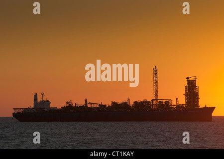 Silhouette di una FPSO Offshore (flottante, produzione, storage offloading) rig in sunset/l'orario di alba. Costa del Brasile. Foto Stock