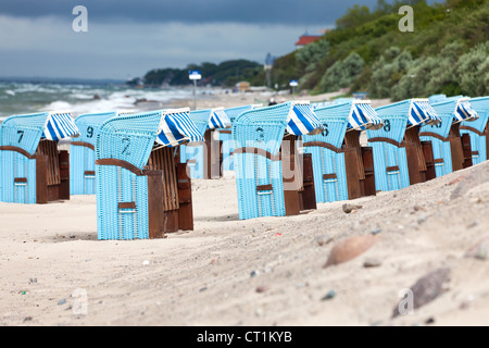 Molte sedie da spiaggia in vimini in una fila sul tedesco del mar Baltico beach Foto Stock