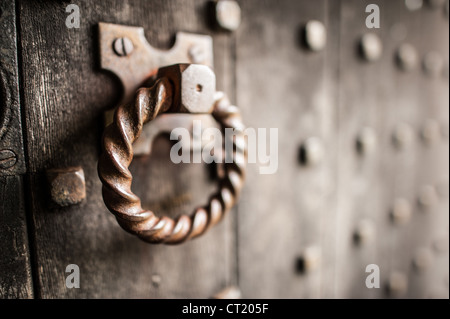 WINCHCOMBE, Inghilterra - un ornato battente porta di ferro adorna una porta di legno massiccio al Castello di Sudeley, una storica residenza reale risalente al XV secolo. Il castello, situato nella regione delle Cotswolds nel Gloucestershire, ha una ricca storia Tudor e si erge su terreni che potrebbero aver ospitato una struttura del castello ancora più antica. Sudeley è particolarmente degna di nota come l'ultima casa e luogo di sepoltura della regina Catherine Parr (c. 1512-1548), la sesta e sopravvissuta moglie di re Enrico VIII. Catherine Parr visse a Sudeley dopo la morte del re e fu posta a riposo nella chiesa di Santa Maria del castello. Il castello Foto Stock