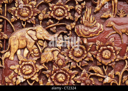 Religiosi intaglio del legno particolare del tempio buddista porta, Thailandia Foto Stock