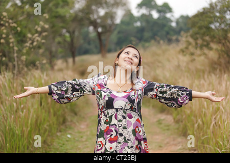 Giovane donna godendo la respirazione nella natura selvaggia, Thailandia Foto Stock