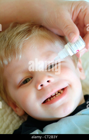 Bambino usando lozione oculare Foto Stock