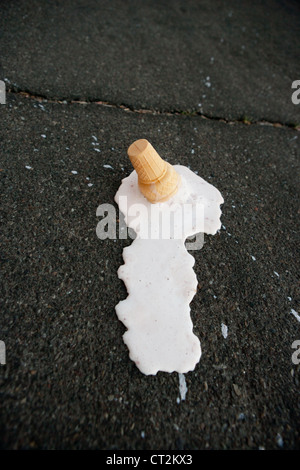 Un cono gelato di fusione a caldo sul marciapiede. Foto Stock