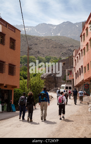 I turisti a piedi in strada, il villaggio di Imlil, Alto Atlante, Marocco, Africa Foto Stock