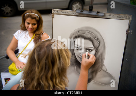 L'artista di strada il disegno di una caricatura di donna di Barcellona sulla rambla Foto Stock