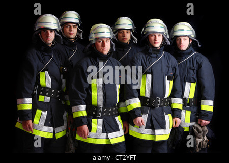 I vigili del fuoco in speciali tute ignifughe, Nomex tuta, casco con visiera, linea di sicurezza. Professional fire mangiare. Foto Stock