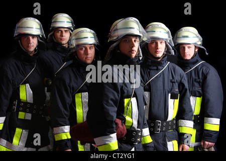 I vigili del fuoco in speciali tute ignifughe, Nomex tuta, casco con visiera, linea di sicurezza. Professional fire mangiare. Foto Stock