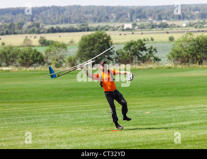 L uomo si lancia in cielo RC glider, sul campo in erba Foto Stock