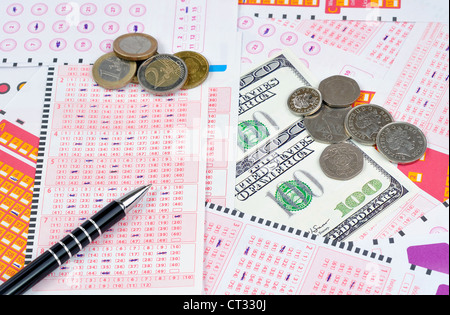 I biglietti della lotteria e diversi tipi di valuta Foto Stock