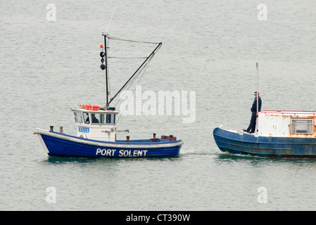 Rimorchiatore tirando una chiatta nel porto di Portsmouth Foto Stock