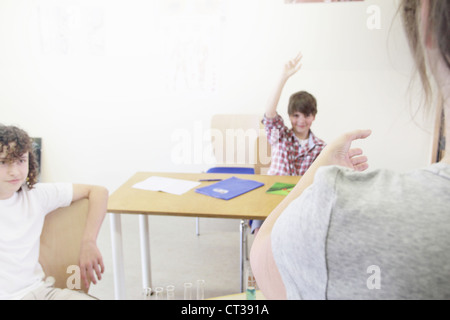 Insegnante chiamando per studenti in classe Foto Stock