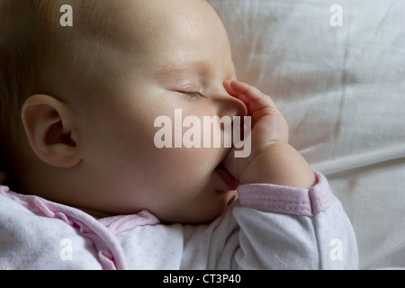 3 mese fa il bambino addormentato su un cuscino succhiare il suo pollice Foto Stock