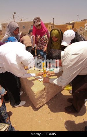 I bambini della scuola da Aswan condurre esperimenti utilizzando le matite per mostrare la posizione del sole a mezzogiorno del solstizio d'estate. Foto Stock