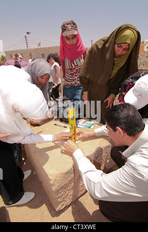 I bambini della scuola da Aswan condurre esperimenti utilizzando le matite per mostrare la posizione del sole a mezzogiorno del solstizio d'estate. Foto Stock