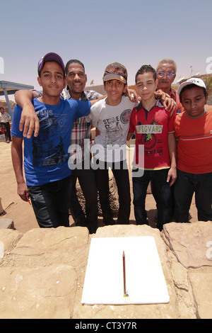 I bambini della scuola da Aswan condurre esperimenti utilizzando le matite per mostrare la posizione del sole a mezzogiorno del solstizio d'estate. Foto Stock