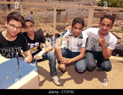 I bambini della scuola da Aswan condurre esperimenti utilizzando le matite per mostrare la posizione del sole a mezzogiorno del solstizio d'estate. Foto Stock