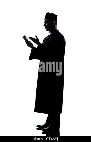 Un uomo caucasico sacerdote leggendo la Bibbia silhouette in studio isolato su sfondo bianco Foto Stock