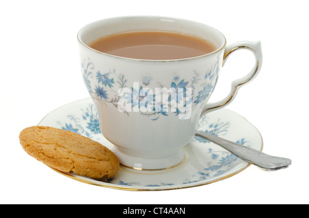 Una tazza di tè caldo servito in un raffinato modellato tazza e piattino con un biscotto - studio shot. Foto Stock