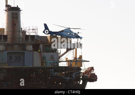 Elicottero atterrato in helideck di P35 FPSO oil rig, lavorando per Petrobras, Brasiliano oil company in Campos Basin, Brasile. Foto Stock