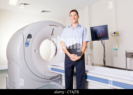 Giovane medico in piedi di fronte a uno scanner MRI Foto Stock