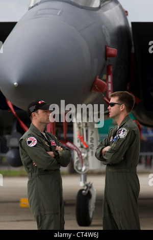 Due US Air Force equipaggio sostare al di sotto del naso del loro F-16C jet da combattimento al salone di Farnborough, Regno Unito. Foto Stock