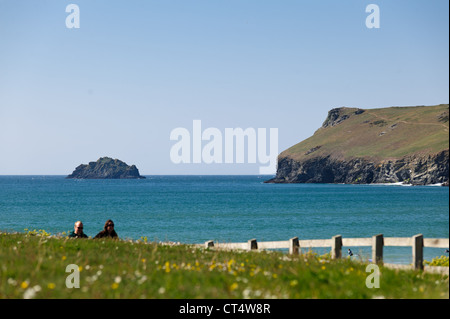 Due escursionisti sul sentiero costiero a Polzeath Bay su una soleggiata giornata d'estate in Cornovaglia Foto Stock