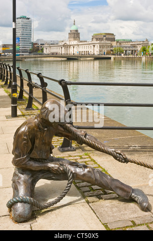 'Il' per guardafili una scultura in bronzo accanto alla City Quay a Dublino con la Custom House in background. Foto Stock