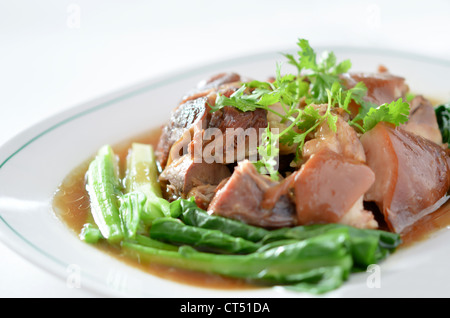 Stufati di carne di maiale il fuso a snodo con kale interno su sfondo bianco Foto Stock