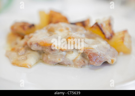 Carni, patate con salsa al formaggio sulla piastra Foto Stock